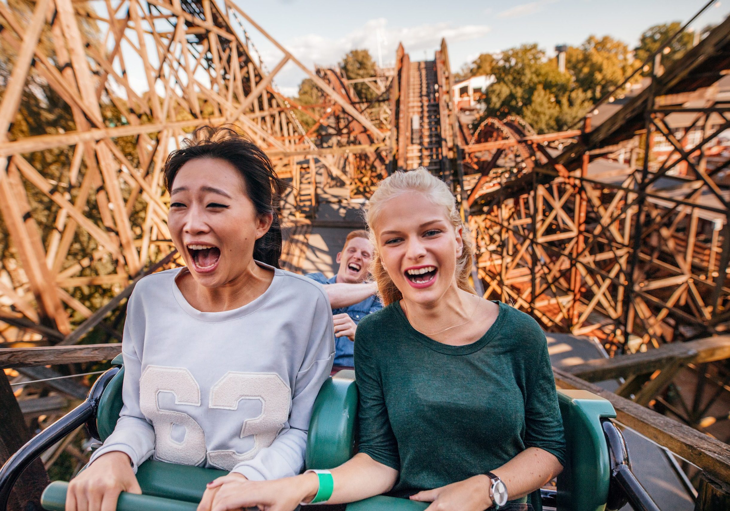 Young friends riding roller coaster ride